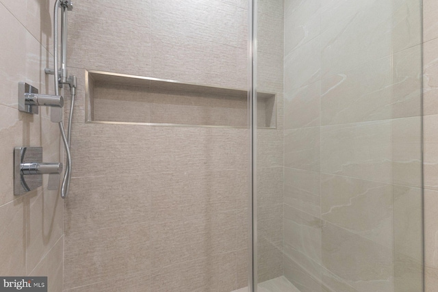 interior details featuring tiled shower