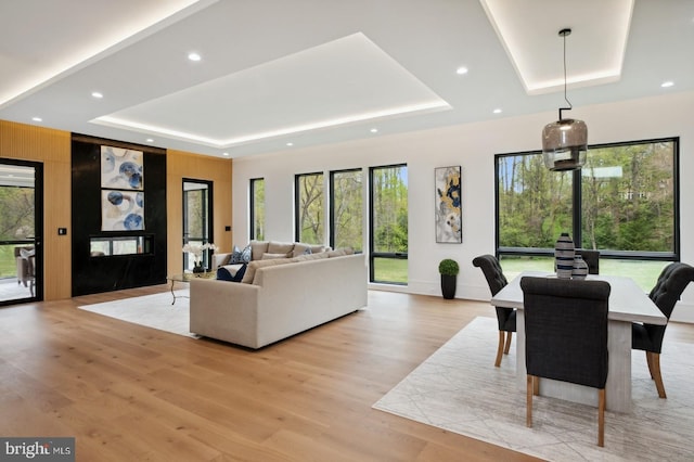 interior space with light wood-style flooring, a tray ceiling, and recessed lighting