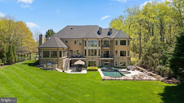 840 Childs Point Rd, Annapolis, MD 21401 - rear view of house with stone siding, a patio, a chimney, a lawn, and an in ground hot tub