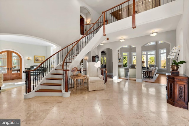 840 Childs Point Rd, Annapolis, MD 21401 - stairway featuring a high ceiling, tile patterned flooring, arched walkways, french doors, and baseboards