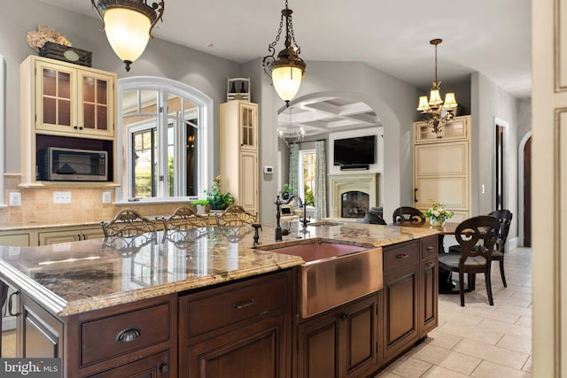 840 Childs Point Rd, Annapolis, MD 21401 - kitchen with an inviting chandelier, a sink, arched walkways, stainless steel microwave, and a healthy amount of sunlight