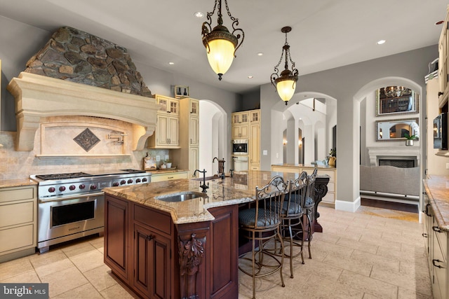 840 Childs Point Rd, Annapolis, MD 21401 - kitchen with decorative backsplash, arched walkways, a sink, stainless steel appliances, and cream cabinetry