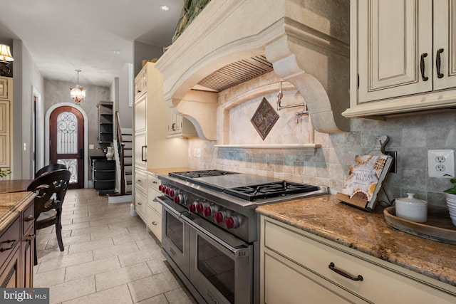 840 Childs Point Rd, Annapolis, MD 21401 - kitchen with backsplash, range with two ovens, custom exhaust hood, dark stone counters, and cream cabinetry