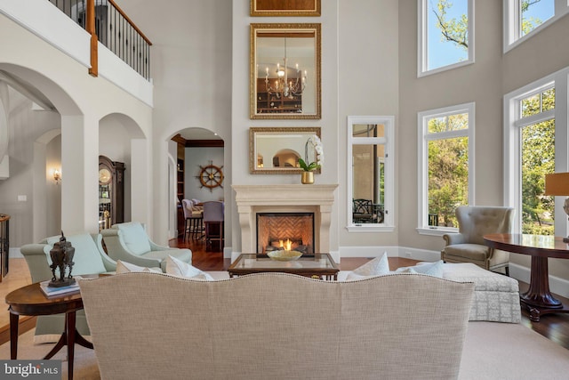 840 Childs Point Rd, Annapolis, MD 21401 - interior space with arched walkways, a towering ceiling, wood finished floors, and a warm lit fireplace