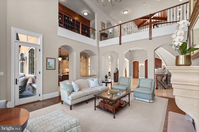 840 Childs Point Rd, Annapolis, MD 21401 - living room featuring a towering ceiling, arched walkways, wood finished floors, baseboards, and a chandelier