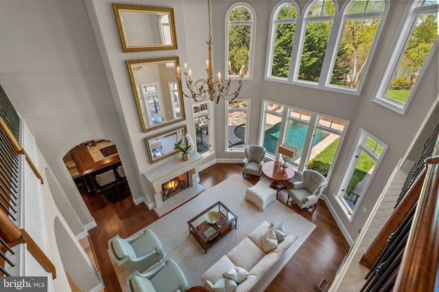 840 Childs Point Rd, Annapolis, MD 21401 - living area with a healthy amount of sunlight, a high ceiling, a warm lit fireplace, and a chandelier