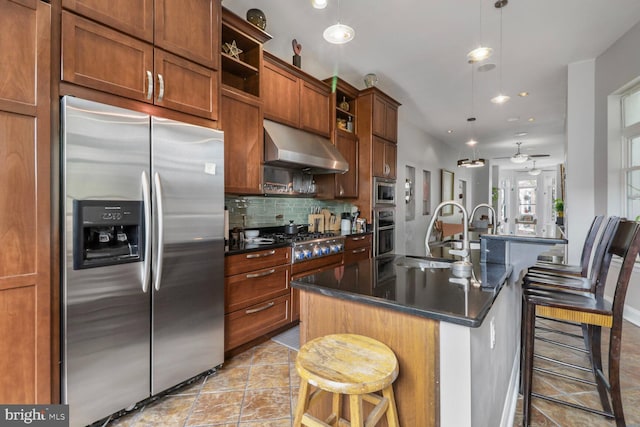 2103 Bolton St, Baltimore, MD 21217 - kitchen featuring dark countertops, appliances with stainless steel finishes, under cabinet range hood, and a kitchen breakfast bar