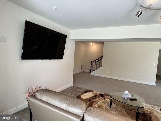 living room featuring stairway and baseboards