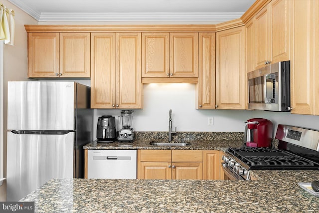 kitchen with a sink, dark stone countertops, light brown cabinetry, ornamental molding, and appliances with stainless steel finishes