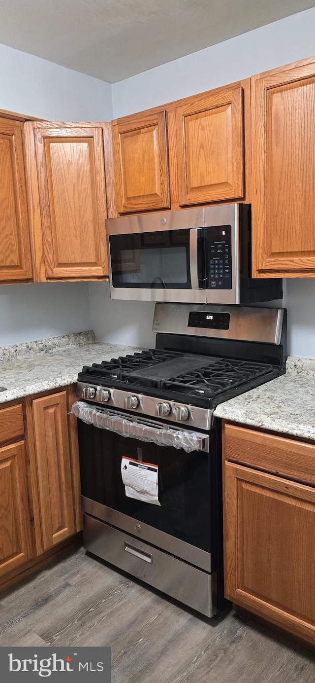 3811 Swann Rd Unit T-1, Suitland, MD 20746 - kitchen with stainless steel appliances, brown cabinets, and wood finished floors