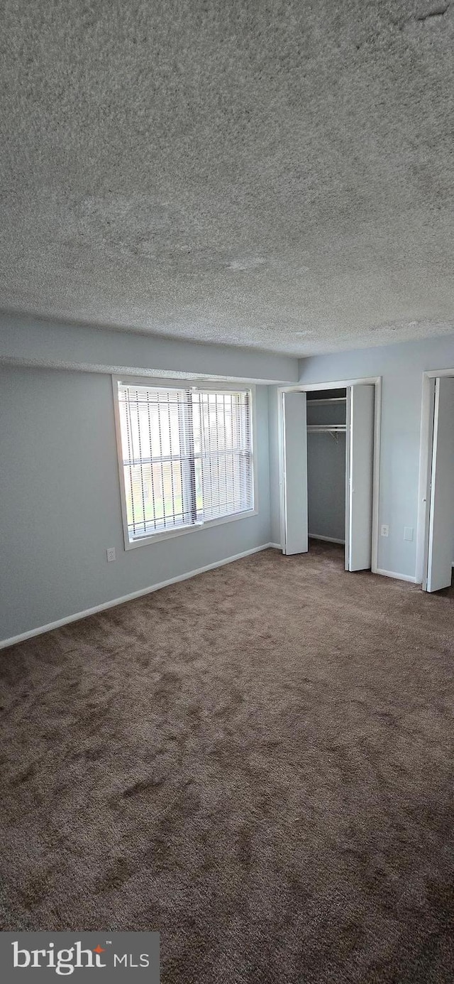 3811 Swann Rd Unit T-1, Suitland, MD 20746 - unfurnished bedroom featuring baseboards, a textured ceiling, carpet, and multiple closets