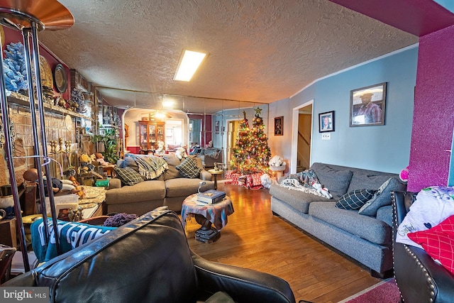 1569 Prospect Ave, Willow Grove, PA 19090 - living area featuring arched walkways, wood finished floors, a textured ceiling, and stairs