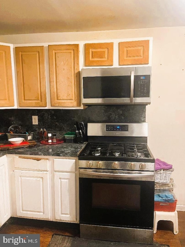 1569 Prospect Ave, Willow Grove, PA 19090 - kitchen with dark countertops, dark wood-style flooring, appliances with stainless steel finishes, and decorative backsplash