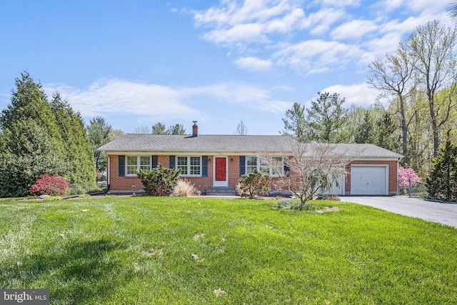 single story home with a chimney, concrete driveway, brick siding, a front yard, and a garage