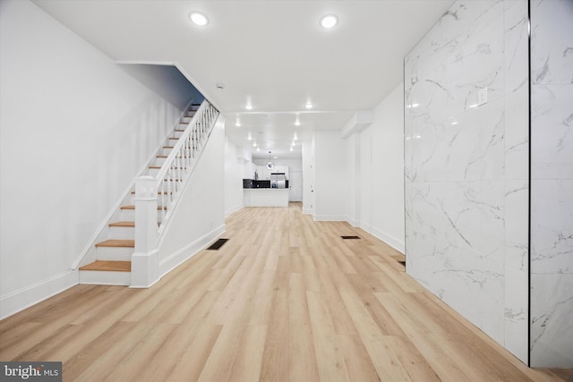 unfurnished living room featuring recessed lighting, wood finished floors, visible vents, and stairs
