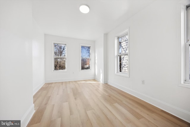 unfurnished room featuring baseboards and light wood-style floors