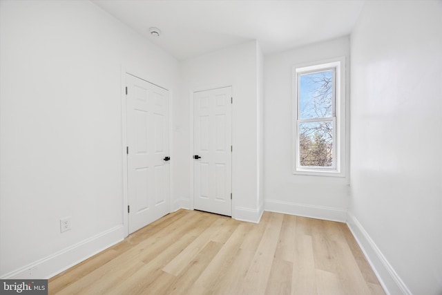unfurnished bedroom featuring light wood-style floors and baseboards
