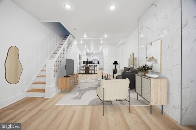 living room with baseboards, wood finished floors, stairs, and recessed lighting