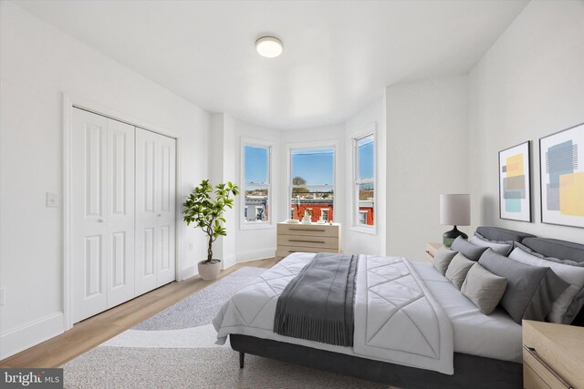 bedroom featuring baseboards, wood finished floors, and a closet