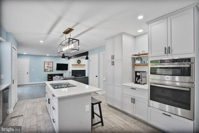 kitchen with light wood-type flooring, light countertops, recessed lighting, and double oven