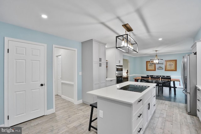 kitchen featuring recessed lighting, light wood-style flooring, a center island, and stainless steel appliances