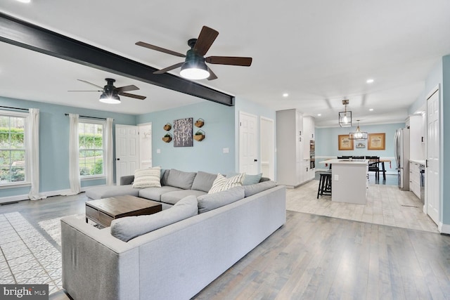 living area featuring recessed lighting, light wood finished floors, a ceiling fan, beamed ceiling, and baseboards