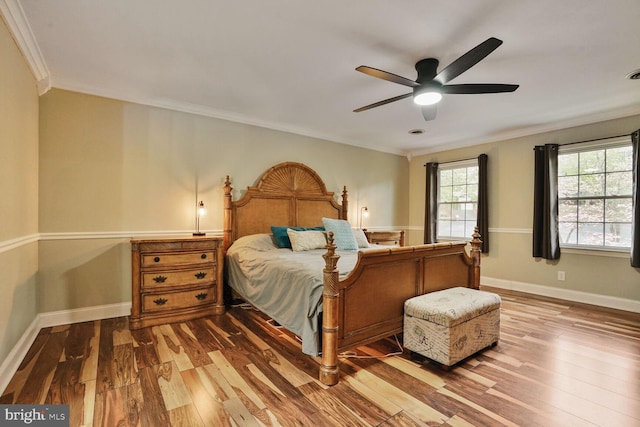 bedroom with ceiling fan, baseboards, wood finished floors, and ornamental molding