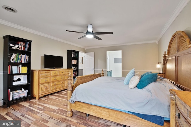 bedroom featuring light wood-type flooring, visible vents, a ceiling fan, and ornamental molding