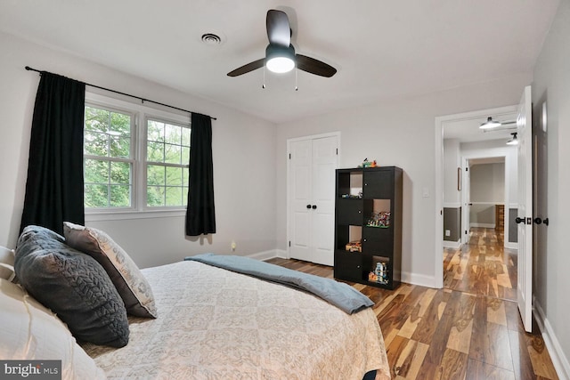 bedroom featuring visible vents, baseboards, and wood finished floors