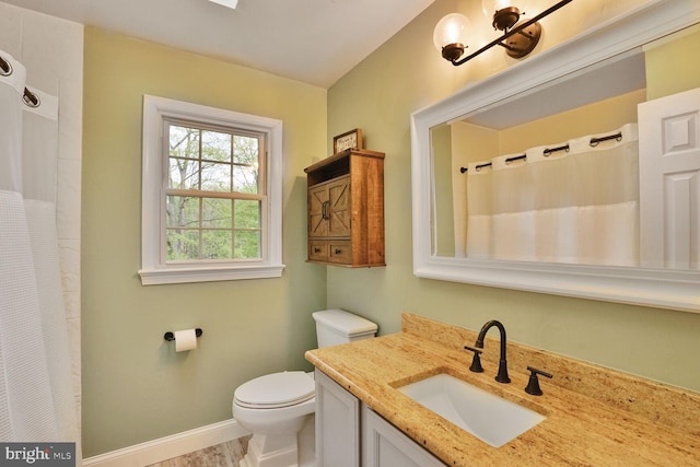 bathroom with baseboards, vanity, a shower with shower curtain, and toilet