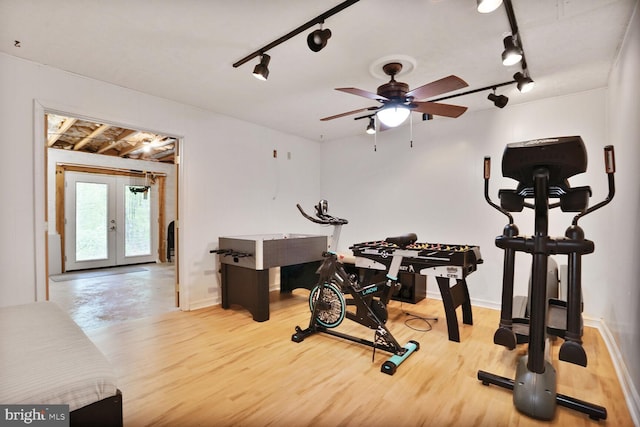 workout area with track lighting, baseboards, french doors, and wood finished floors