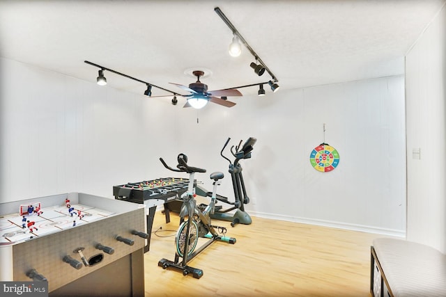 exercise room with track lighting, light wood finished floors, and ceiling fan