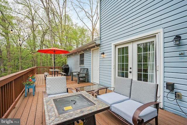 wooden deck featuring an outdoor living space with a fire pit