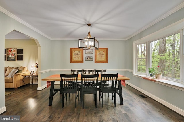 dining room featuring dark wood finished floors, an inviting chandelier, visible vents, arched walkways, and crown molding