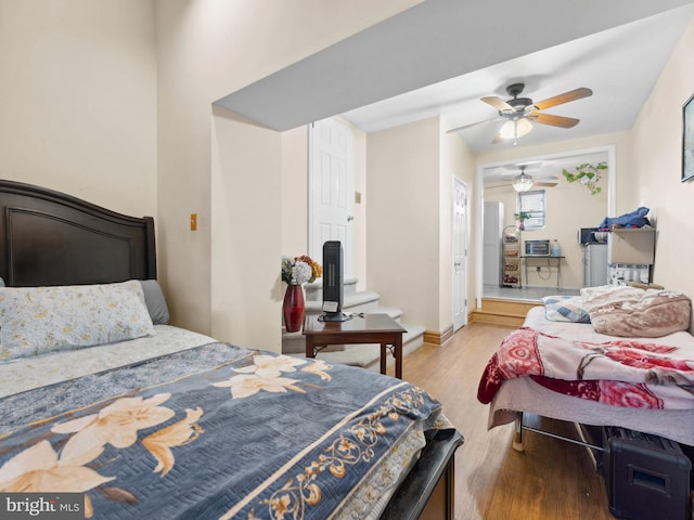 bedroom with light wood-type flooring, baseboards, and ceiling fan