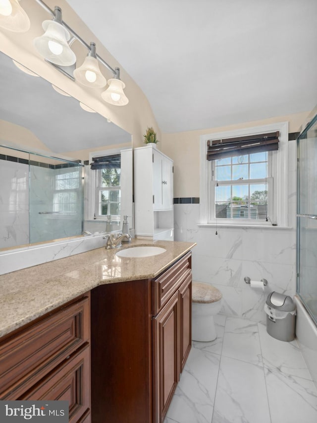 bathroom featuring toilet, a wealth of natural light, lofted ceiling, and vanity