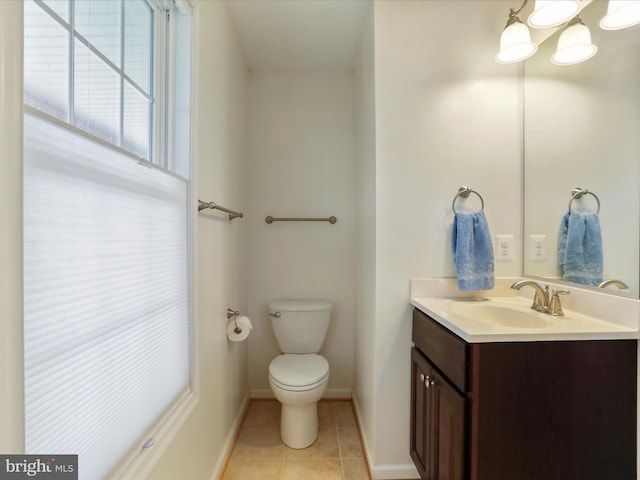 bathroom with baseboards, tile patterned flooring, vanity, and toilet