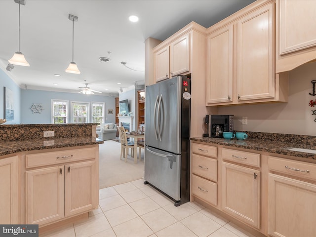 kitchen with a ceiling fan, freestanding refrigerator, and light brown cabinetry