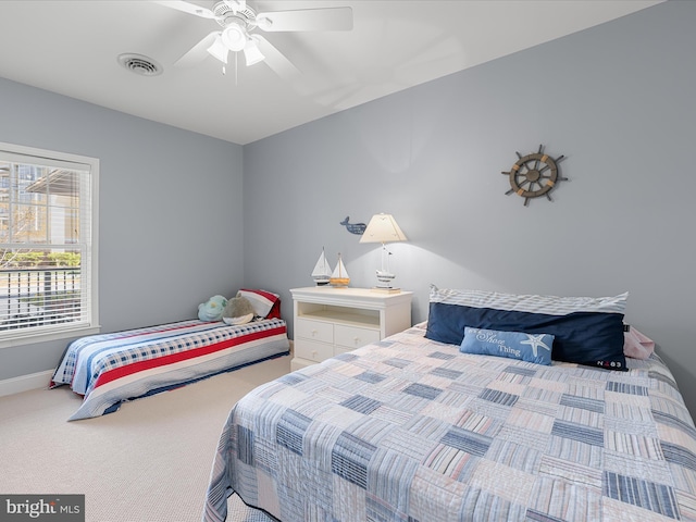 carpeted bedroom with baseboards, visible vents, and ceiling fan