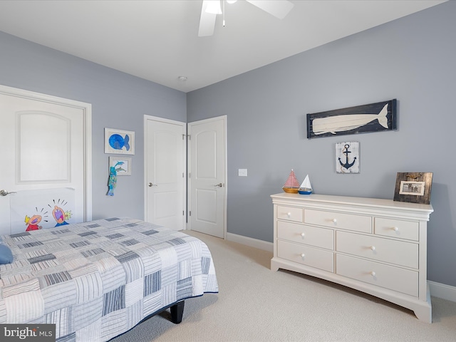 bedroom with a ceiling fan, baseboards, and light carpet