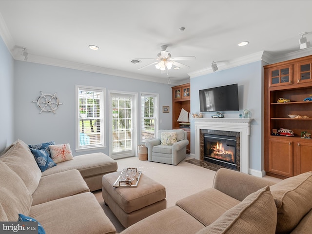 living room featuring recessed lighting, a premium fireplace, a ceiling fan, and ornamental molding