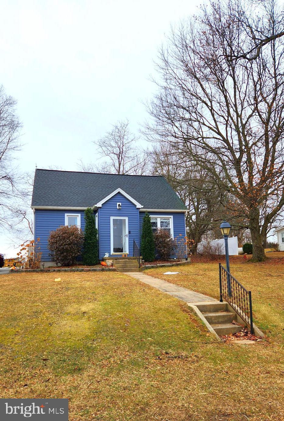 view of front of house with a front lawn and a shingled roof