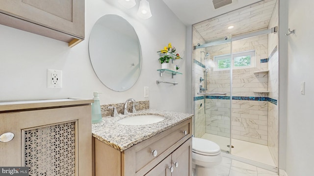 full bath with marble finish flooring, vanity, a stall shower, and toilet