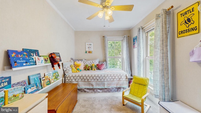 carpeted bedroom with crown molding and a ceiling fan