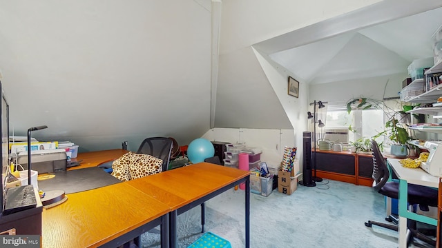 carpeted home office with vaulted ceiling