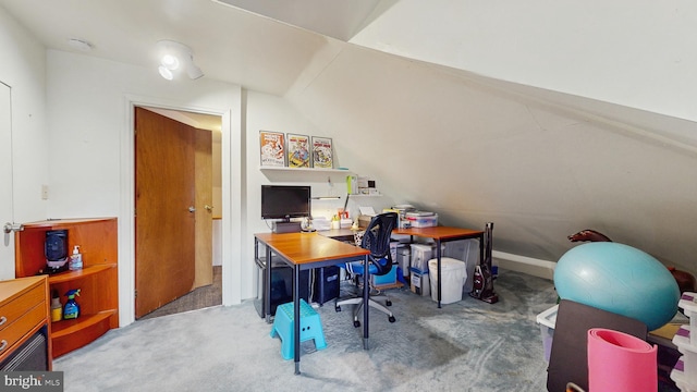 carpeted office with lofted ceiling