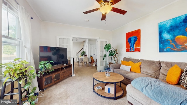 living room featuring carpet, french doors, a ceiling fan, and ornamental molding