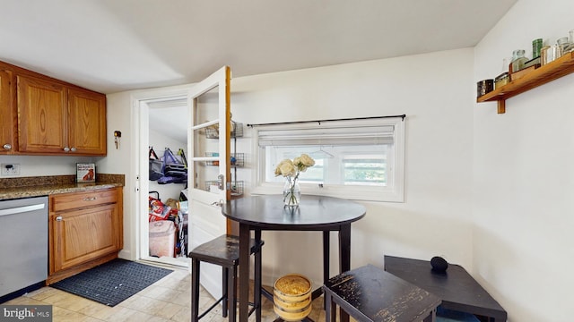 kitchen featuring stainless steel dishwasher, brown cabinetry, and open shelves