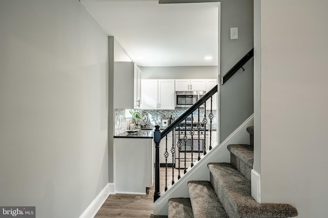 staircase with wood finished floors and baseboards
