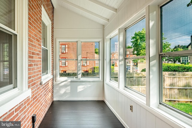 unfurnished sunroom featuring hardwood / wood-style floors and brick wall